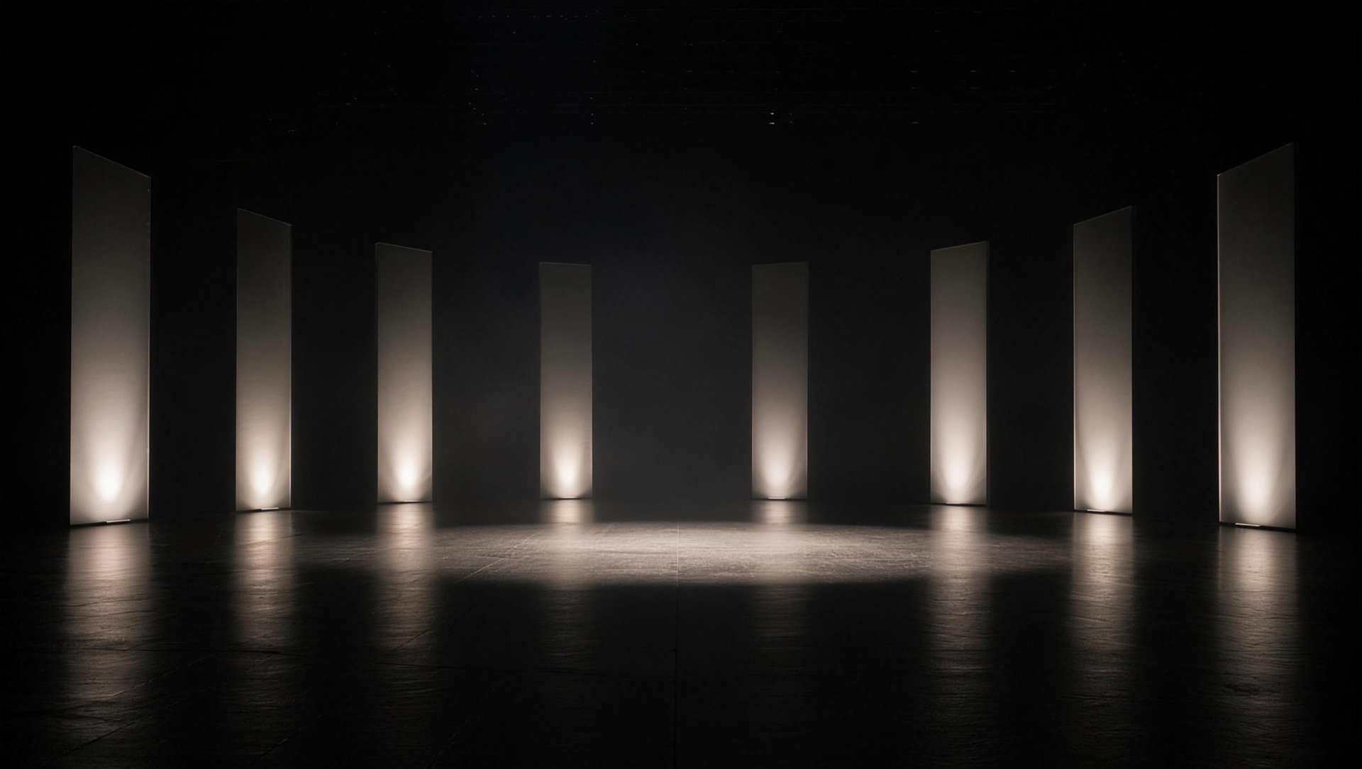Dark virtual stage with tall light panels around an open presentation area
